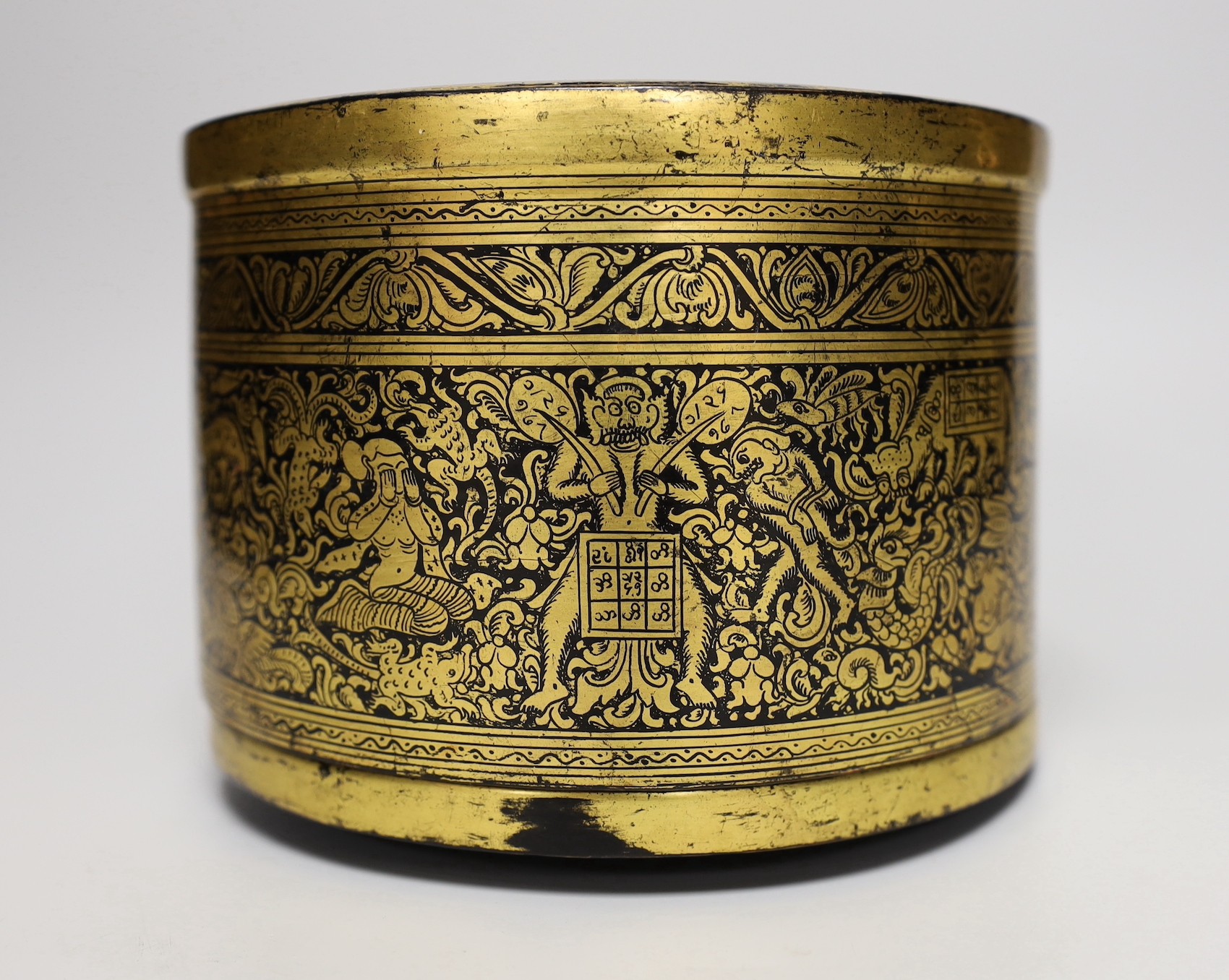 A Burmese gilt decorated papier mache cylindrical box and cover, 14cms high